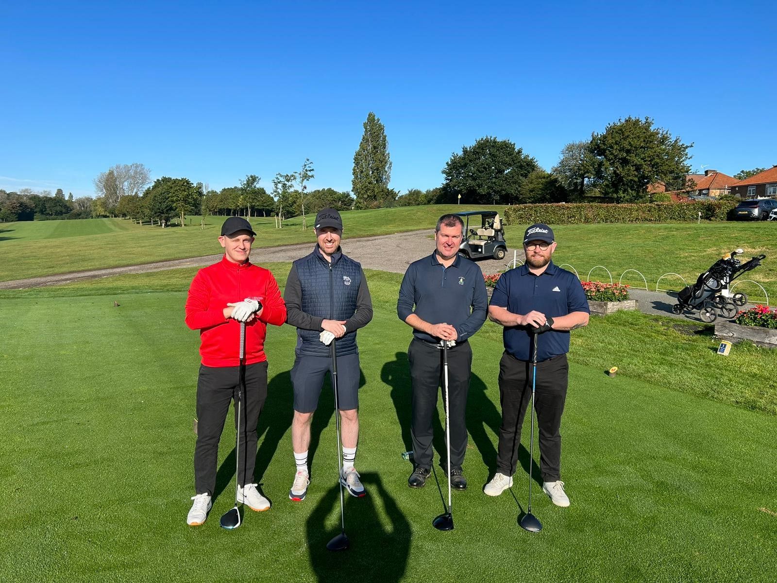 4 men standing for a photo on the golf course